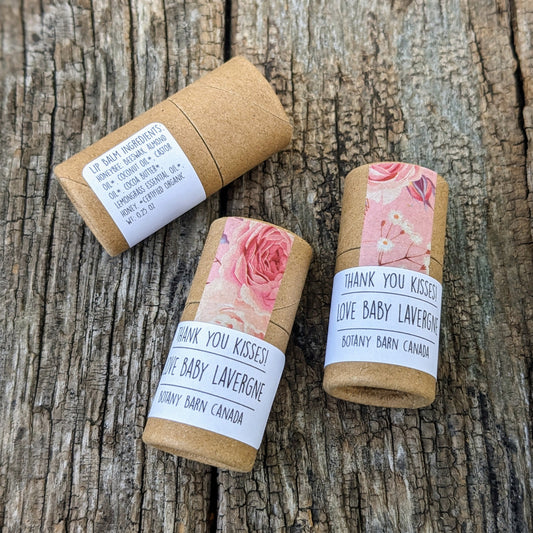Cardboard lip balm tubes display custom labels on the front and ingredient list on the back. Decorated with floral tape.