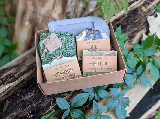 Handmade gift set including three bars of artisan soap, a crocheted washcloth, and a diatomite soap dish, packaged in a kraft gift box.