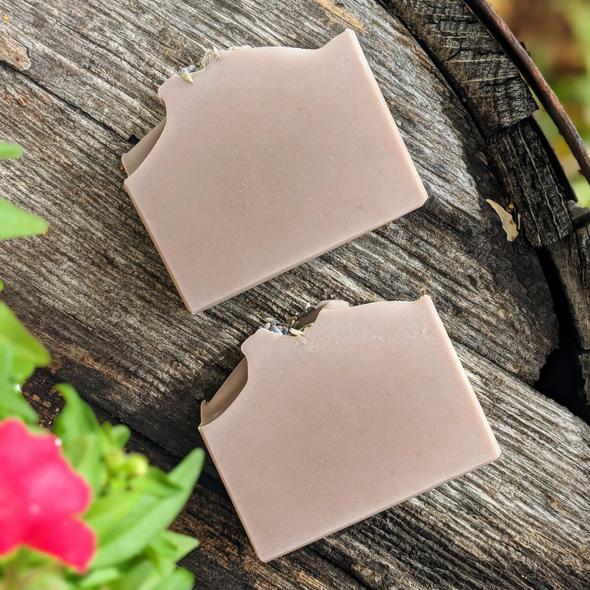 Two bars of purple soap displayed on a wooden surface