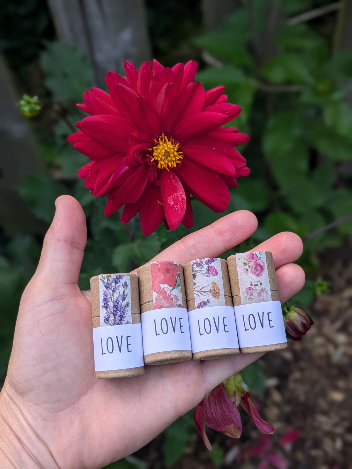 Four lip balms tubes with floral decal and LOVE printed on the label