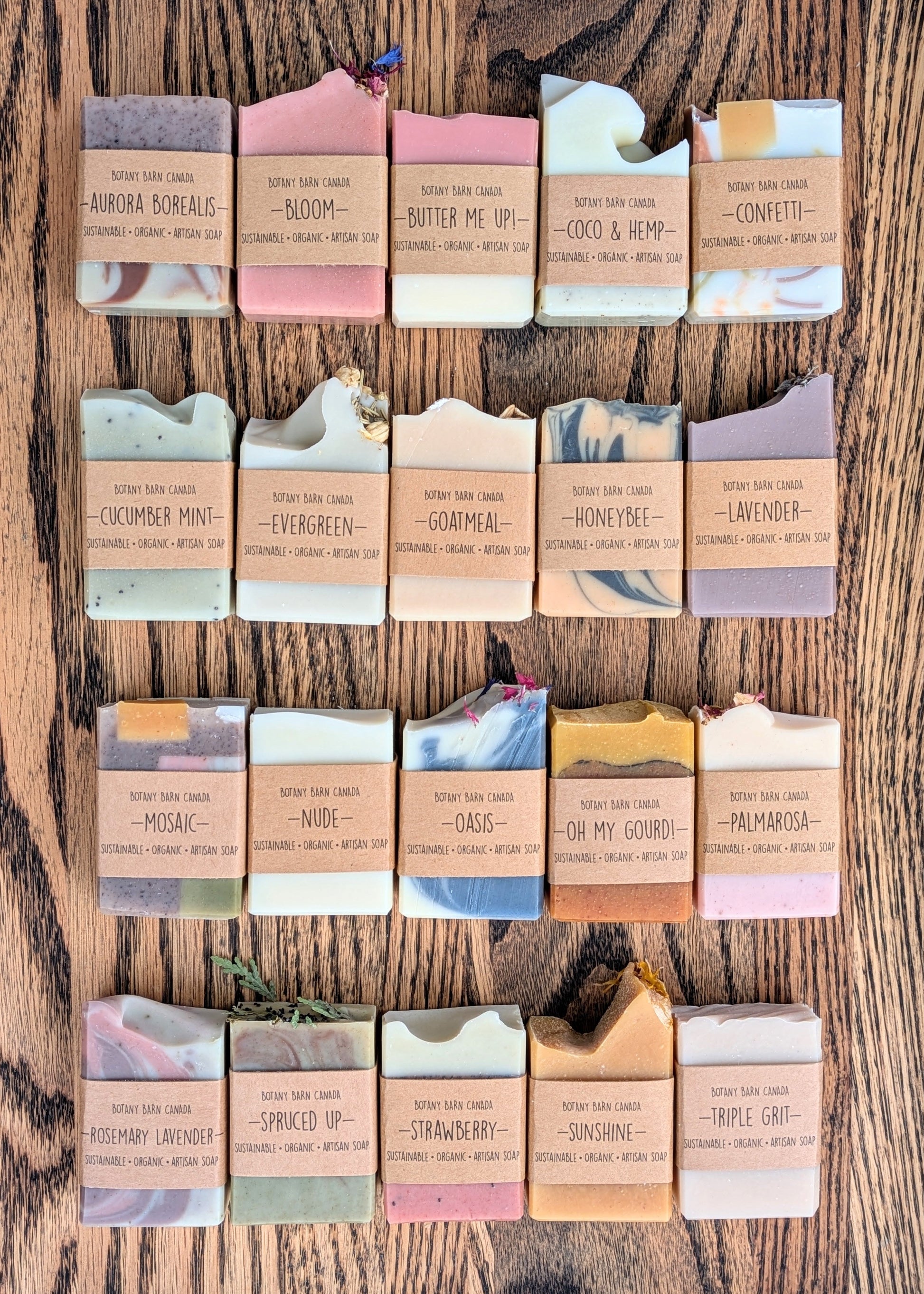 Assorted soap bars with visible Botany Barn Barnding and product names on a wooden surface