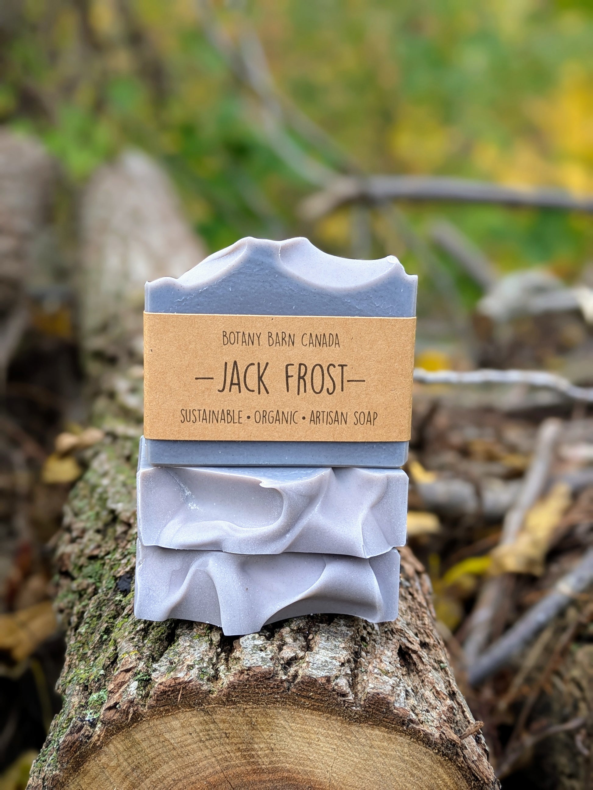 Bar of soap with a 'Jack Frost' label on a log against a natural background