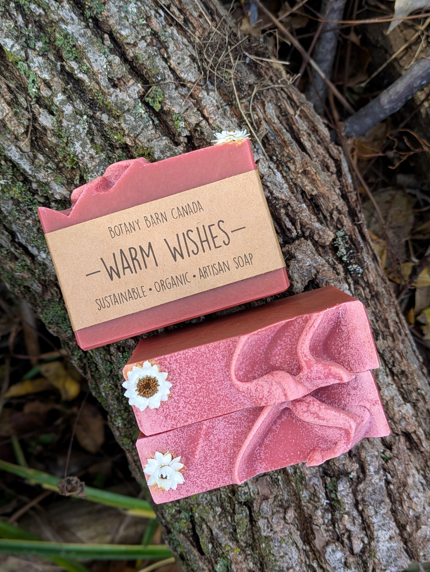 Two red soaps with a 'Warm Wishes' label on a tree branch.