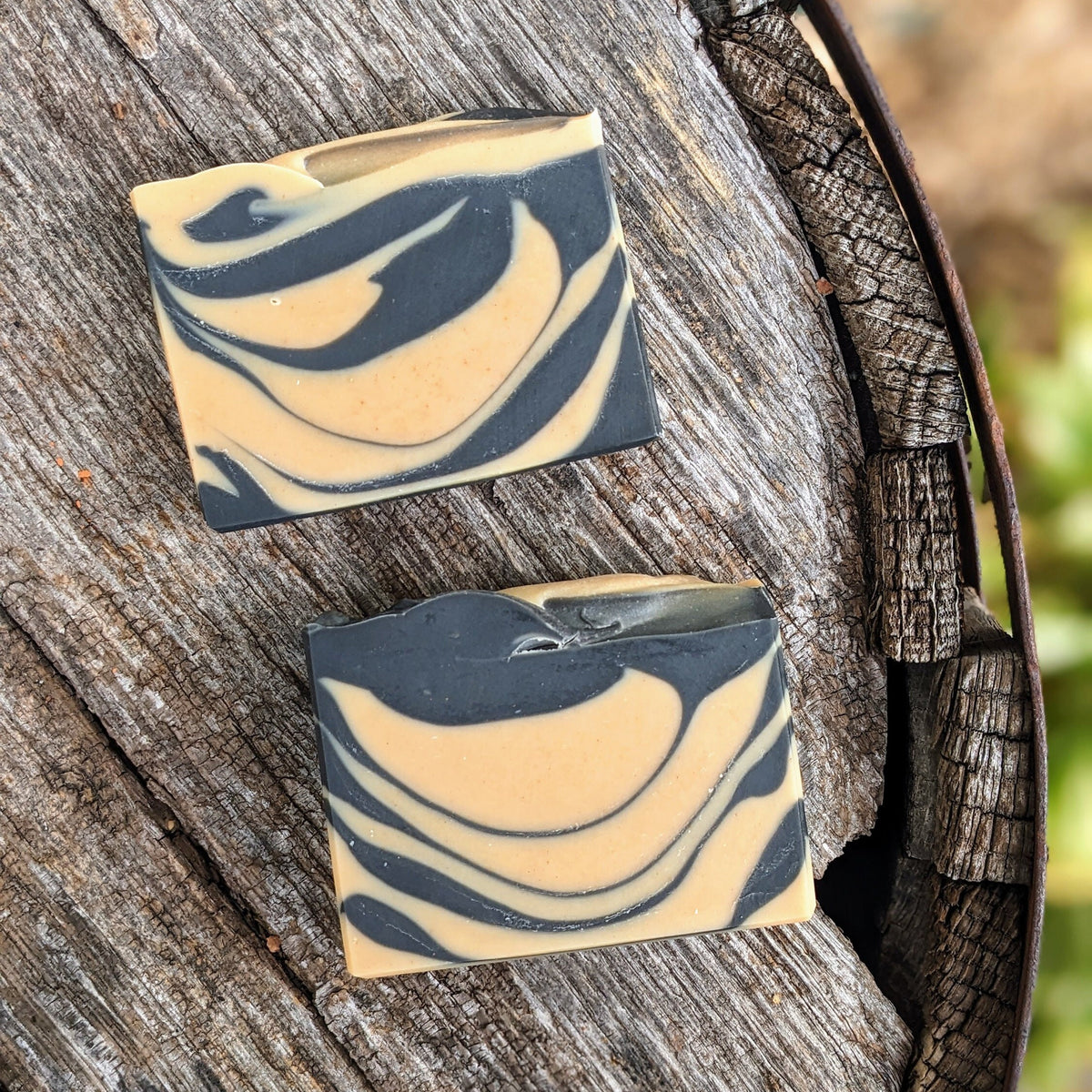 Two swirled soap bars on a wooden surface