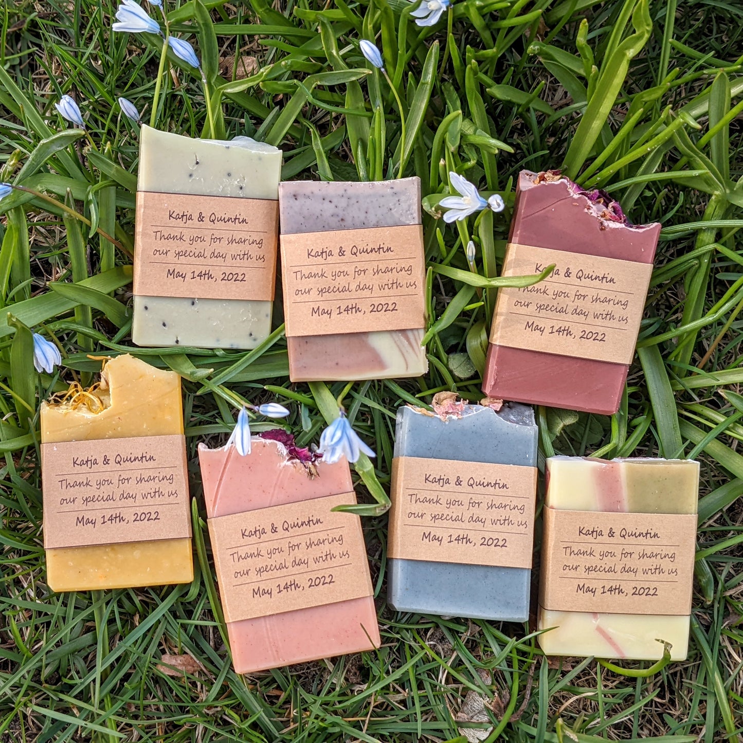 An assortment of colourful soap bars displayed on a background of green grass