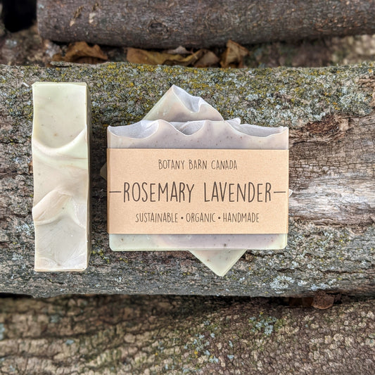 Bars of handmade artisan soap, top and front view. The soap is pink, purple & green in colour. A brown label reads the name of the company, Botany Barn Canada and the name of the soap, Rosemary Lavender.