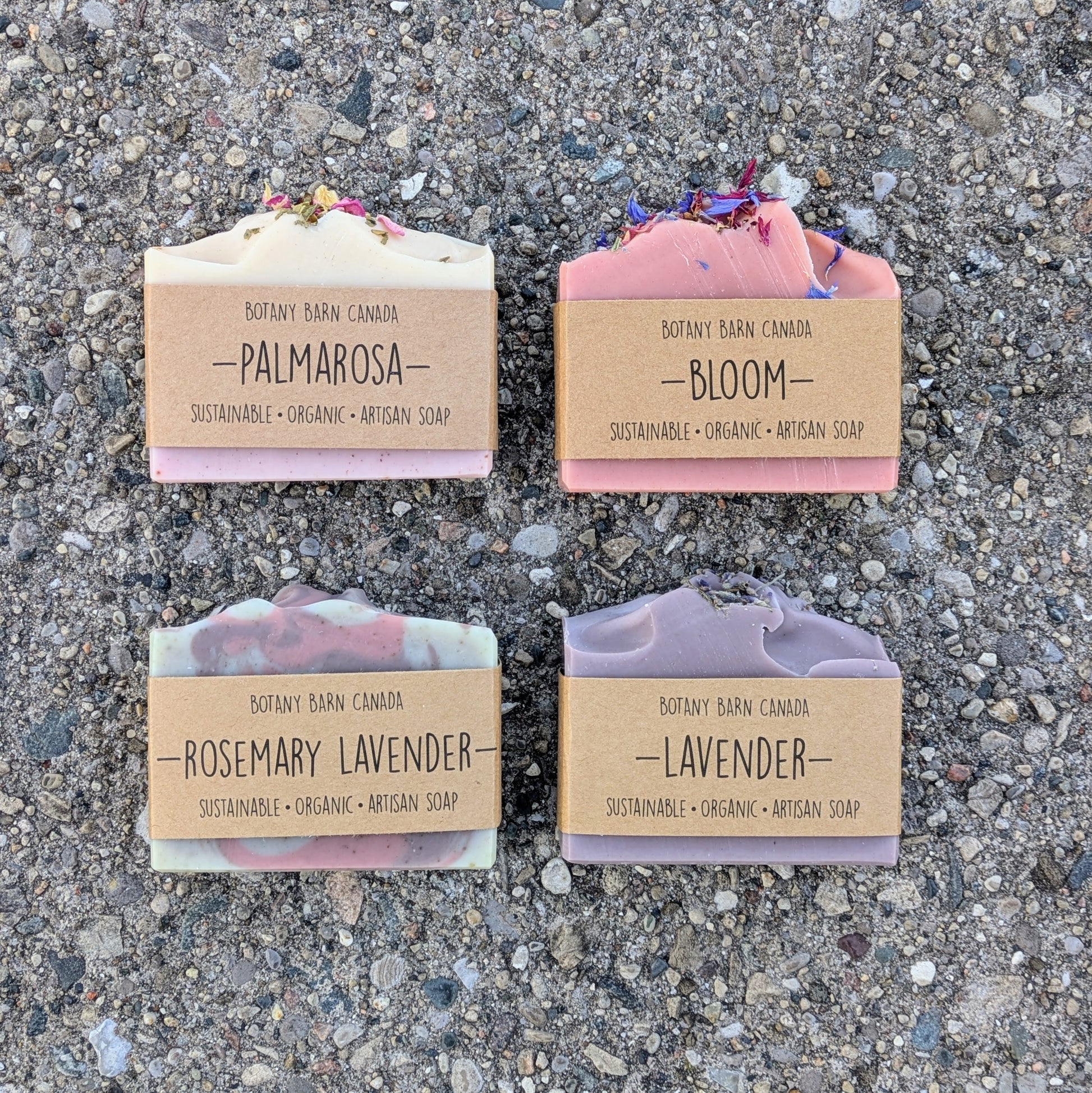Four bars of soap with labels on a textured surface