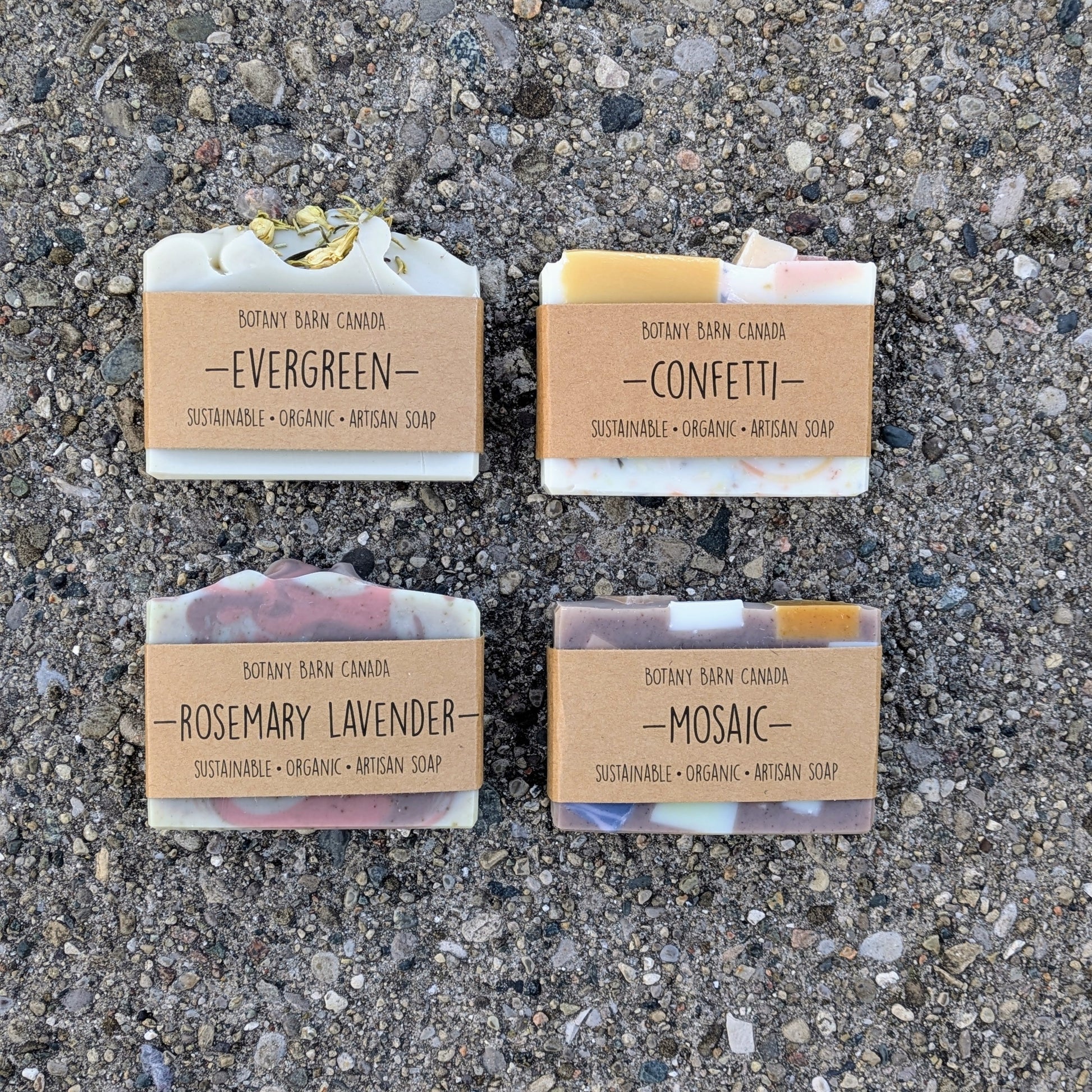 Four soap bars with labels on a textured surface