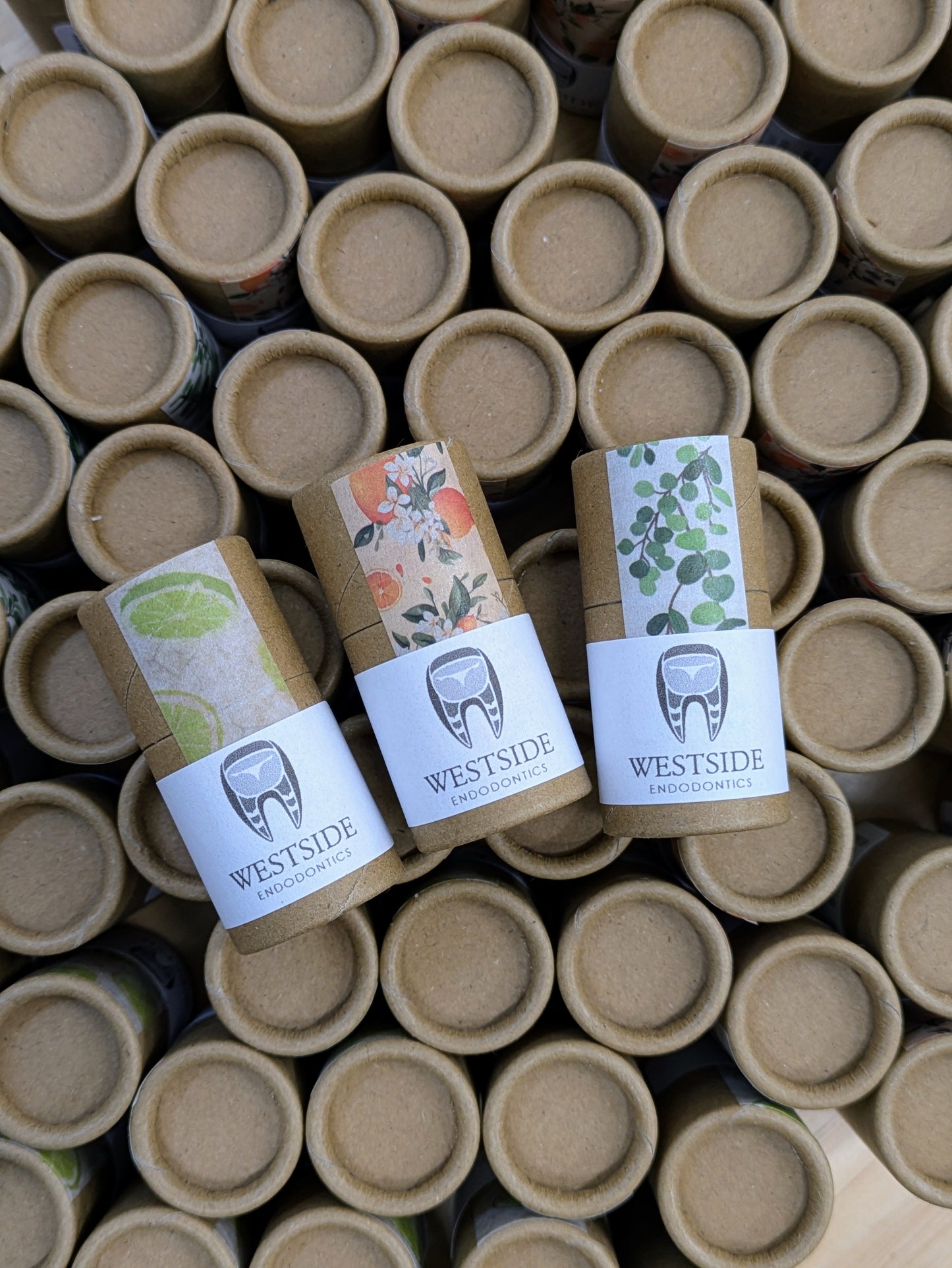 Three lip balm tubes with corporate branding and logo visible