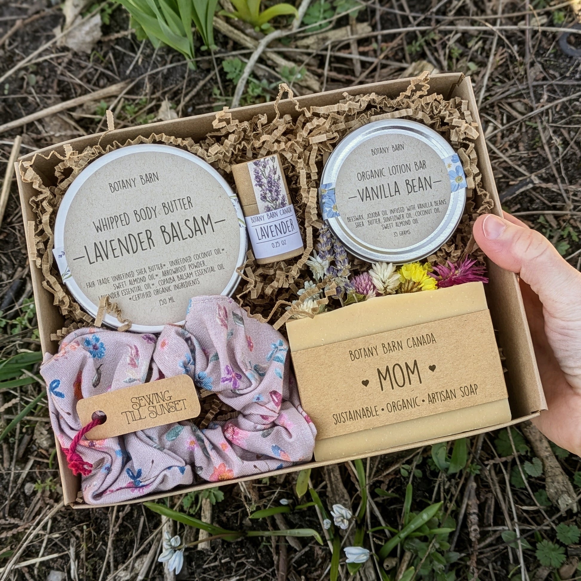 Gift set with soap bar, body butter, lip balm and scrunchie in a natural setting