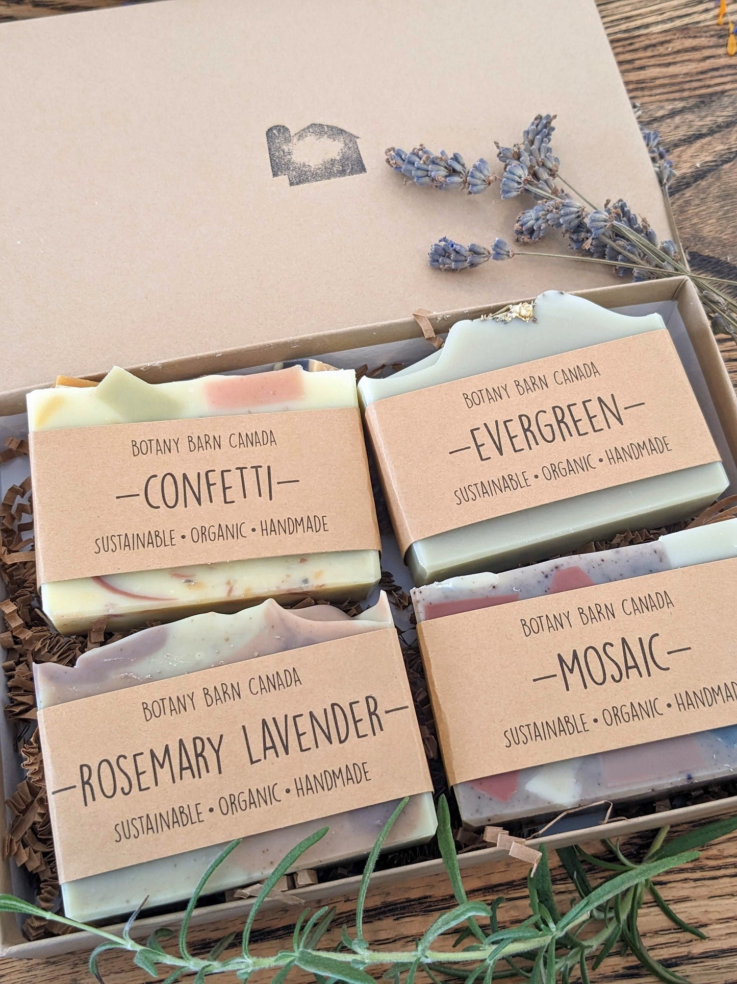 Four soaps in a box with labels on a wooden surface