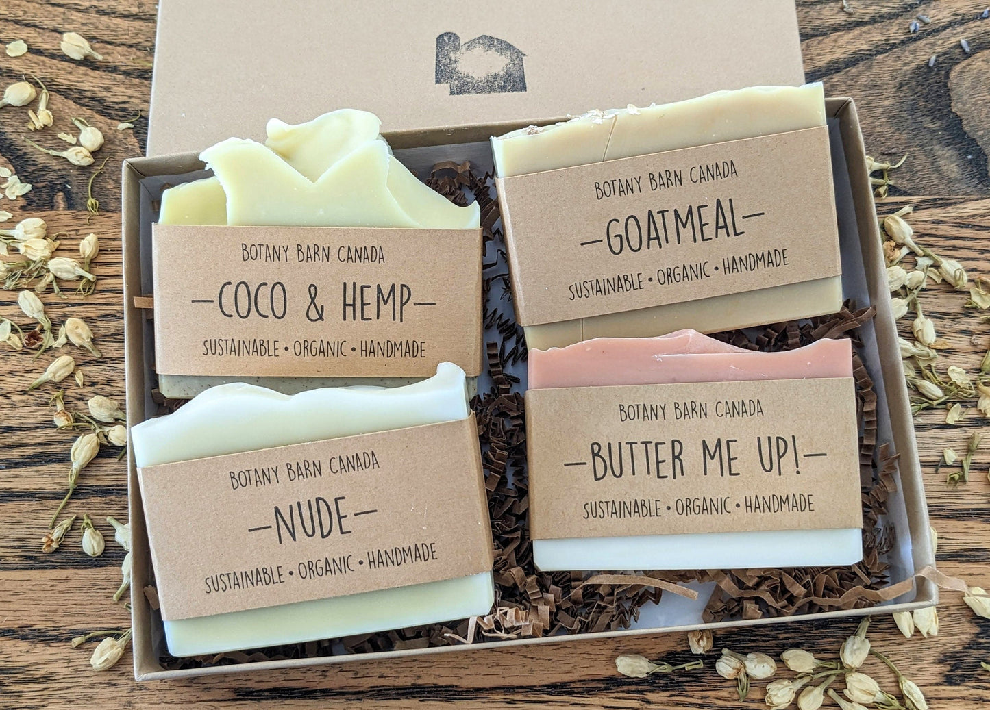 Four soaps in a box with labels on a wooden surface