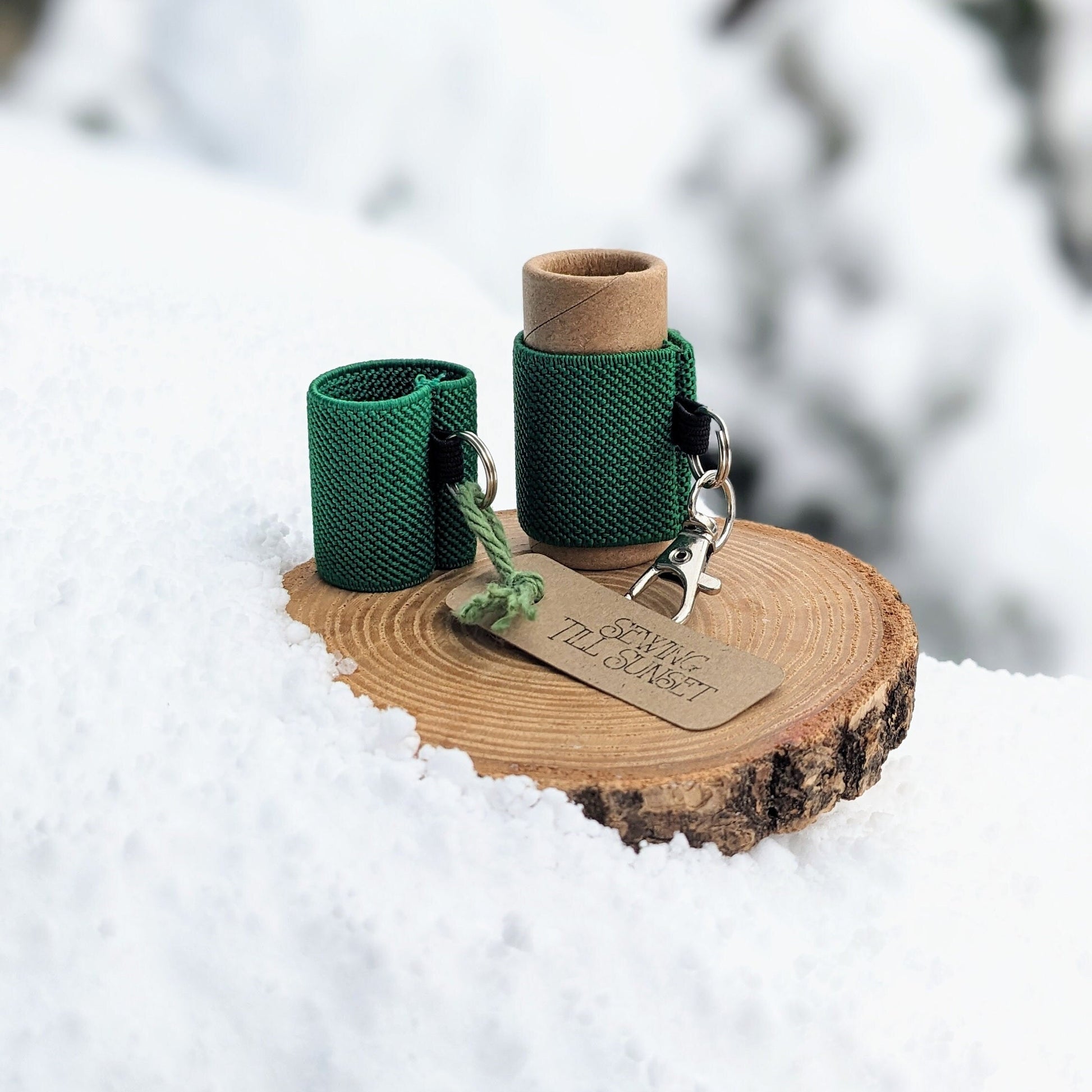 Green lip balms holders displayed on a wooden surface in the snow