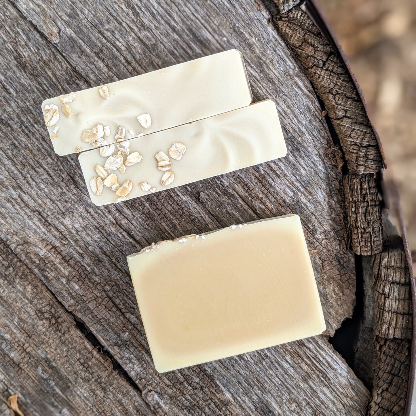 Three soap bars on a wooden surface