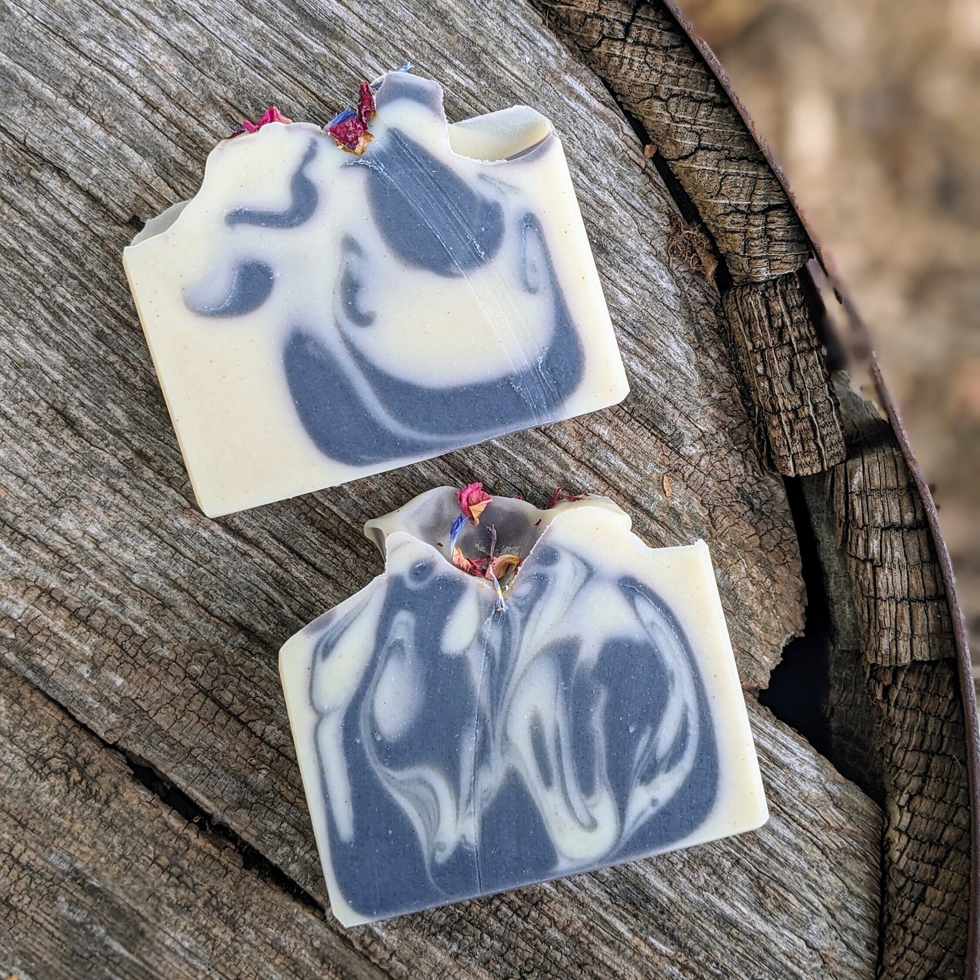 Two soap bars with a blue and white marbled design on a wooden surface